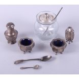 A George V three-piece silver cruet set of octagonal form, a silver topped glass preserve jar and