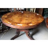 An early 19th century mahogany and rosewood circular table, on central turned column, four reeded