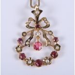 An Edwardian yellow metal pendant set with pink tourmalines and seed pearls, on yellow metal