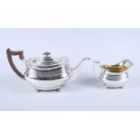 A George V silver teapot and matching milk jug, on squat bun feet, 30.9oz troy gross