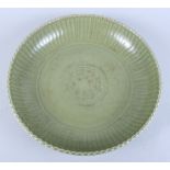 A Chinese Ming design celadon porcelain fluted charger with central medallion of lotus flower