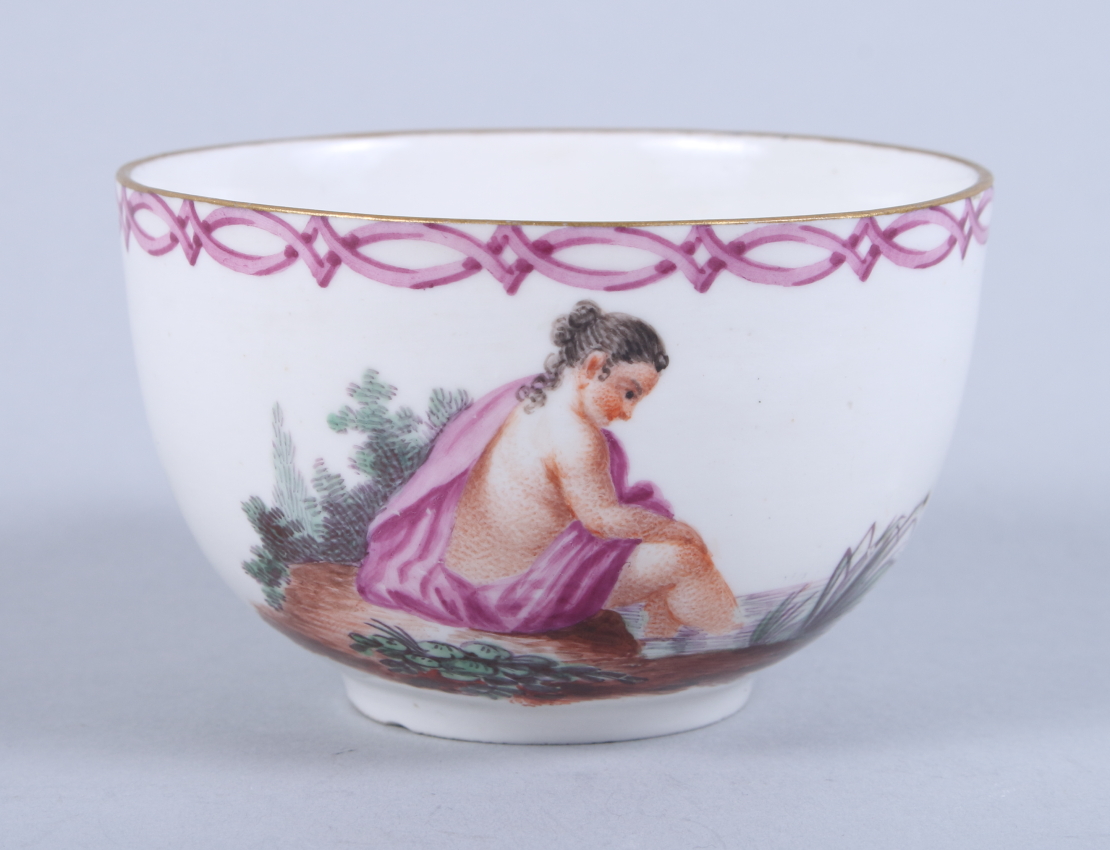 An 18th century German porcelain cabinet cup, decorated bathing maiden (chip to foot rim)