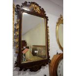 A Georgian mahogany framed wall mirror, surmounted a gilt carved hoho, 27" x 19"