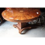 An early 19th century mahogany and walnut circular table, on square column terminating in four