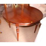 A cherrywood circular extending dining table, with two extra leaves, 45" x 78" (when fully extended)