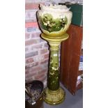 A Leeds Art Pottery jardiniere stand decorated blossom on a green ground, 33" high, and a