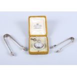 Two pairs of silver sugar tongs and a silver cased open faced fob watch with enamelled dial