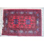 A Caucasian rug with two blue star guls on a red ground and multi bordered in shades of red, blue