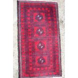 A Bokhara rug with four hooked guls on a red ground, 78" x 39" approx