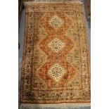 A Persian style rug with three lozenges and animal border on a rust ground, 78" x 49" approx