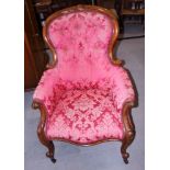 A late Victorian spoon back walnut framed arm chair, on splay supports and castors