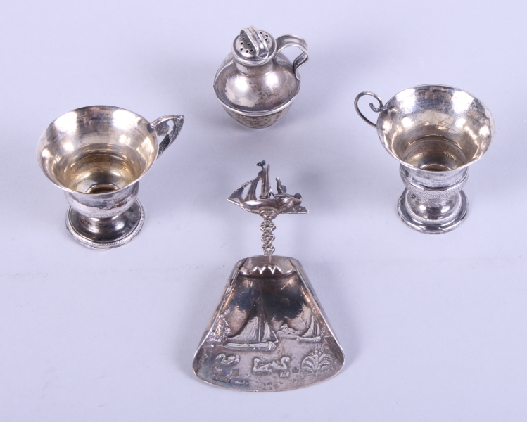 A Dutch silver caddy spoon, decorated boating scenes, import marks Burthold Muller, two miniature