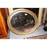 An oval gilt framed wall mirror, plate 19 1/2" x 22"