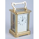 A brass cased carriage clock with white enamel dial and Roman numerals