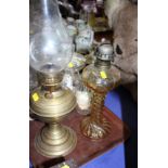 An oil lamp with twisted glass reservoir (missing chimney), a brass oil lamp and two cut glass jugs