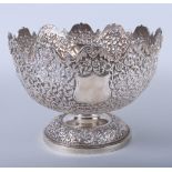 An Indian white metal pedestal fruit bowl, embossed and engraved with wild animals on a scrolled