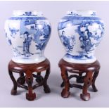 A pair of Chinese blue and white bulbous vases with figure decoration, 9" high, on hardwood stands