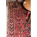 A Caucasian tribal rug with central medallion, birds, flowers and rosettes on a pink ground,