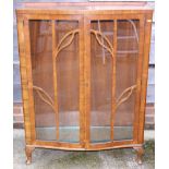 A 1950s walnut bowfront display cabinet, on cabriole supports, 34" wide