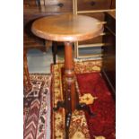 An oak circular top jardiniere stand, on turned column and tripod splay support, 15" dia