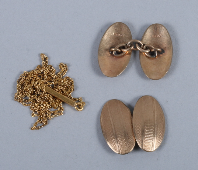 A pair of 9ct gold cufflinks with engine turned decoration and a yellow metal chain, 8g gross