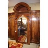 A mid 19th century figured mahogany breakfront arch top triple wardrobe, fitted drawers, shelves