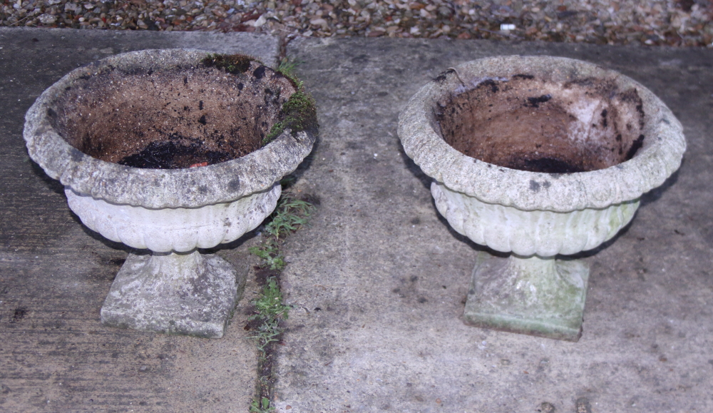 A pair of cast stone planters, on square bases, 17" wide