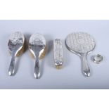 A silver mounted four-piece dressing table set, a silver napkin ring and a number of silver