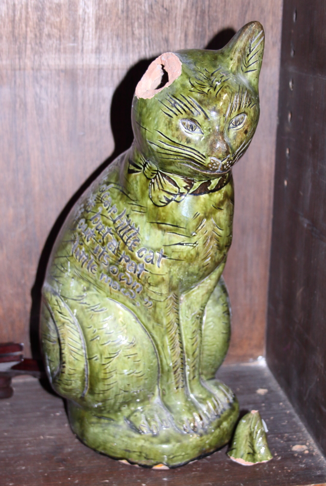 An Ewenny green glazed pottery cat, 15 1/4" high (damaged ear)