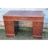 A mahogany double pedestal desk with red leather tooled lined top, fitted nine drawers, on block