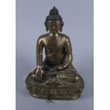 A late 19th century cast and gilt brass model of a seated Thai Buddha, on shaped lotus leaf base,