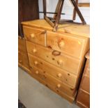 A pine chest of two short and three long drawers with knob handles, on block base