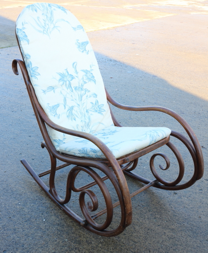 A bentwood rocking chair with cane seat and back and loose cushions