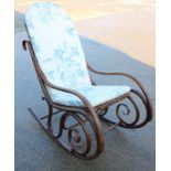 A bentwood rocking chair with cane seat and back and loose cushions