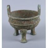 A Chinese bronze Archaic design two-handled foot vessel with relief cast dragon decoration, on three