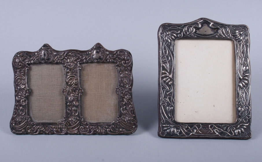 A silver Arts & Crafts embossed photograph frame, 7" high, and an embossed silver double