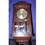 A 1930s oak wall clock with silvered dial and Arabic numerals