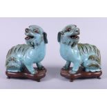 A pair of Chinese green glazed Dogs of Fo, 6 1/2" high, on carved hardwood stands