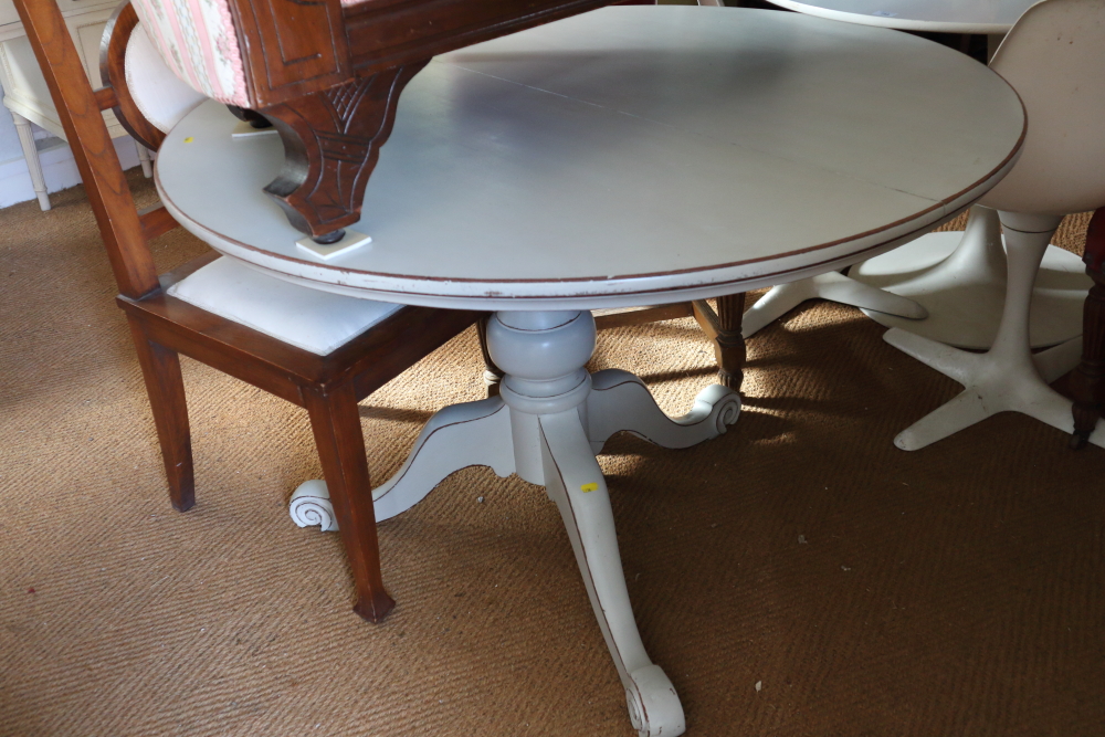 A painted and distressed mahogany circular tilt top dining table, on tripod splay support, 48" dia