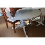 A painted and distressed mahogany circular tilt top dining table, on tripod splay support, 48" dia