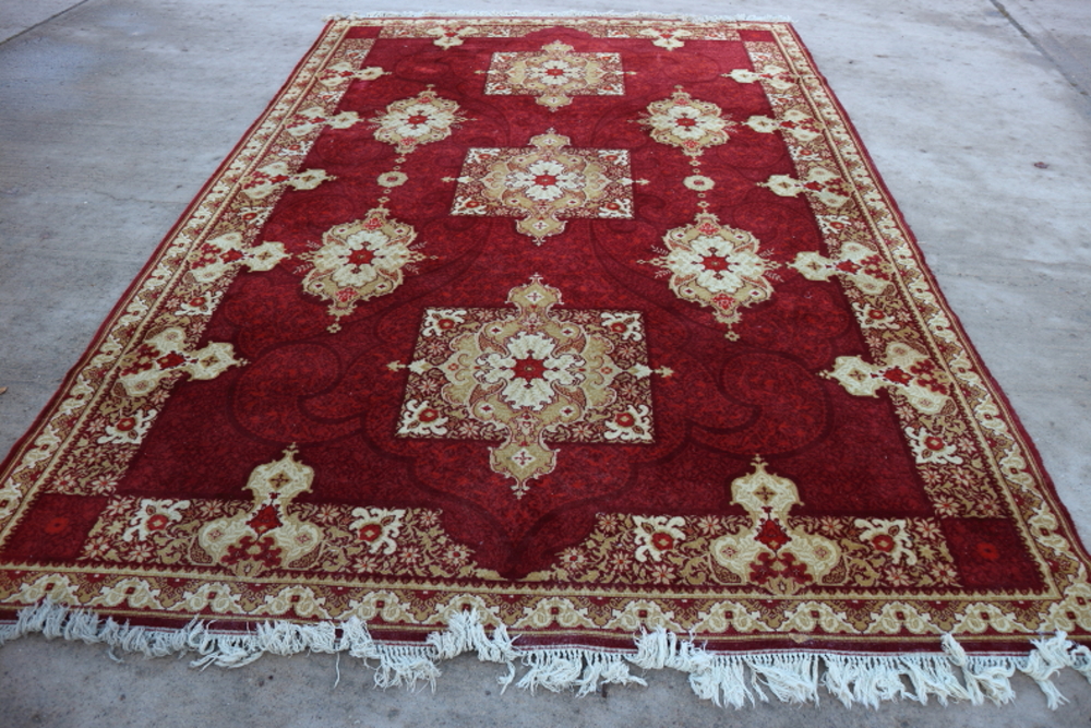A wool pile "Louis de Poortere" carpet with three medallions on a red ground, 98" x 138" approx