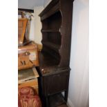 An oak dresser with open shelves over cupboards, on barley twist supports and open shelf, 54" wide