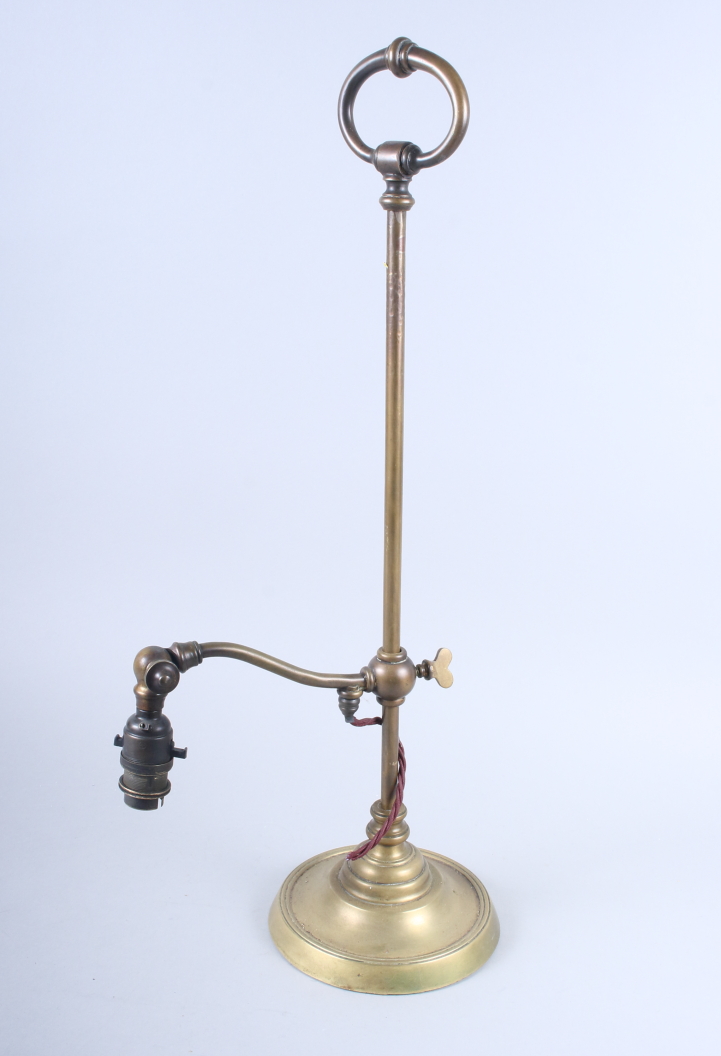 A brass adjustable table lamp, on circular base