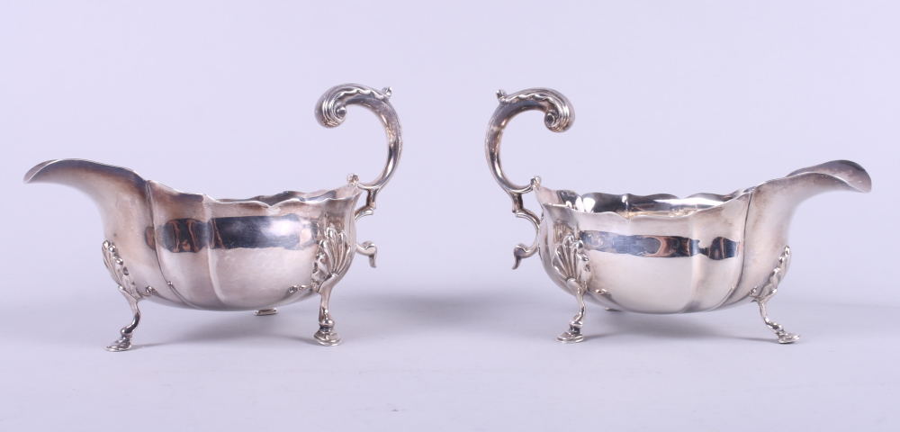 A pair of Victorian silver sauce boats with scroll handles, on hoof feet with shell shoulders, 11.