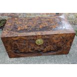 A Chinese carved camphor wood blanket box with figure decoration, 40" wide (damages)