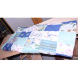 A patchwork quilt with rectangular panels of predominantly blue and green patterned fabric, 82" x