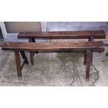 A pair of 18th Century oak "pig" benches, on splay supports, 56" long