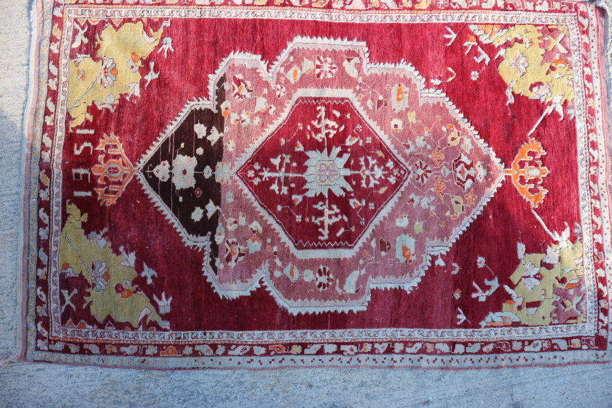 A Persian rug with central medallion in shades of red with yellow corner panels, 52" x 79" approx