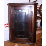 An oak corner cabinet enclosed glazed door, 28" wide