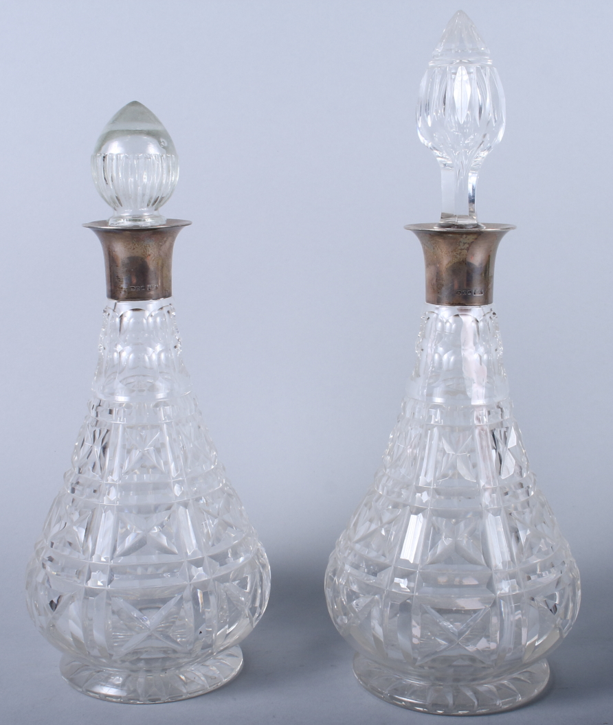 A pair of Mappin & Webb silver topped cut glass decanters and two stoppers